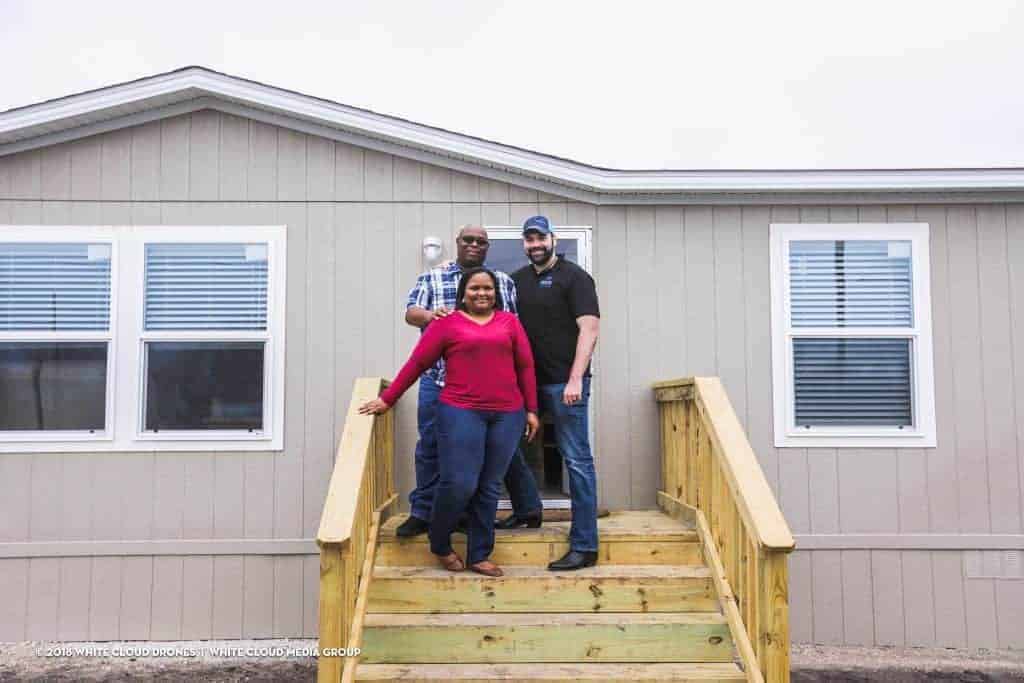 The Smith family with Alberto Piña on the steps to their new home.