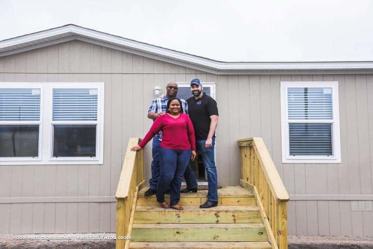 The Smith family with Alberto Piña on the steps to their new home.