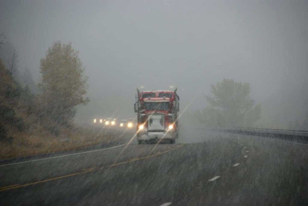 truck moving mobile home down highway to relocate