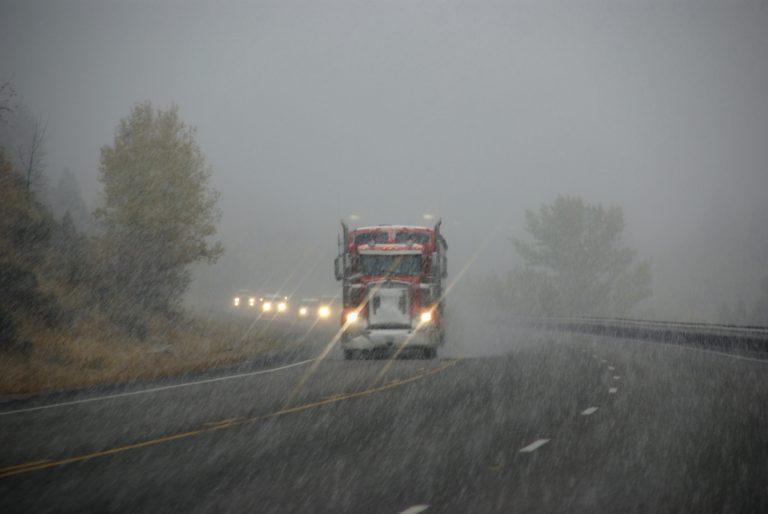 truck moving mobile home down highway to relocate