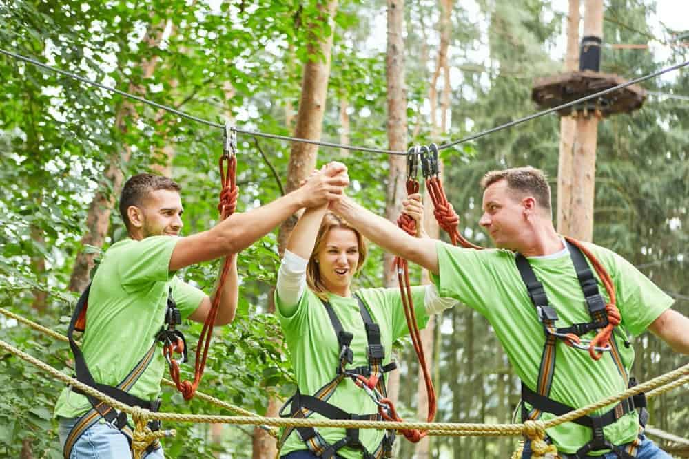 Three young adults on a ropes course