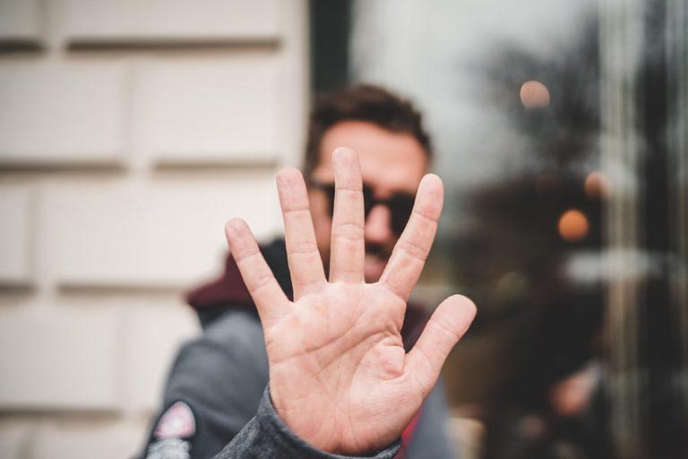 man holding up 5 fingers