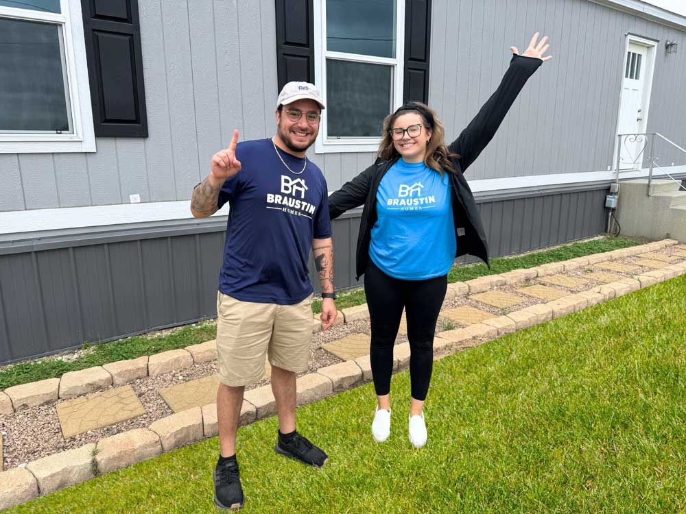 Xander and Faith showing off some newly installed metal skirting on a mobile home