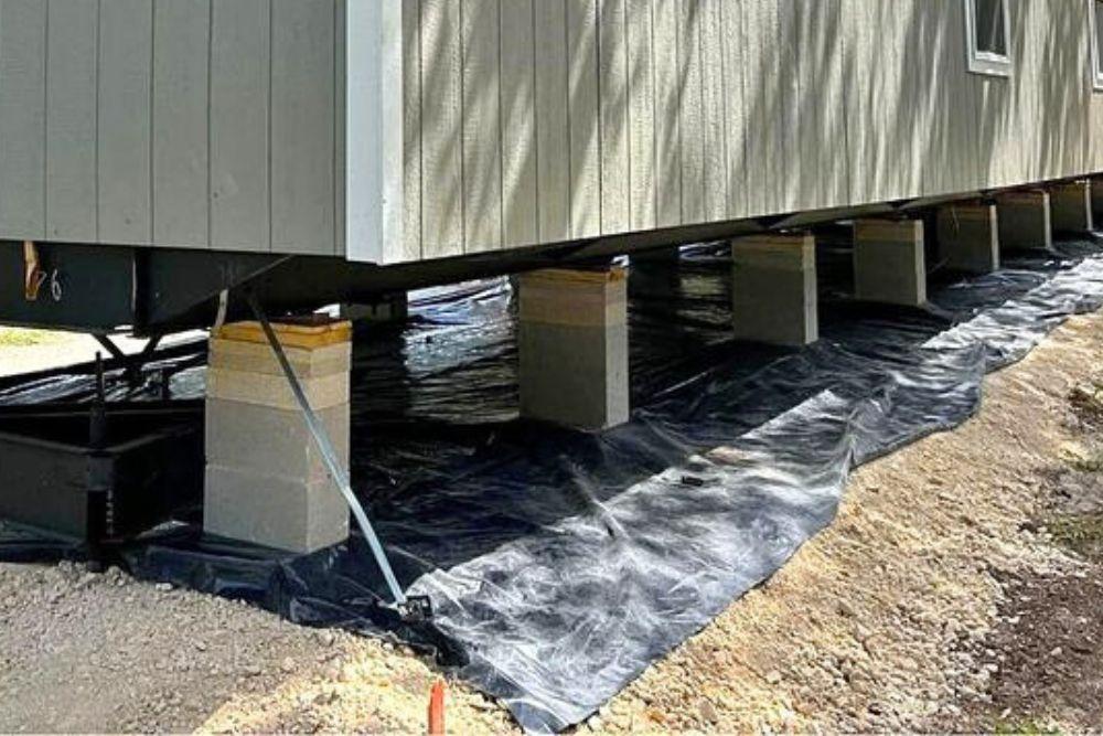 New mobile home set on bricks and tied down after setup complete.